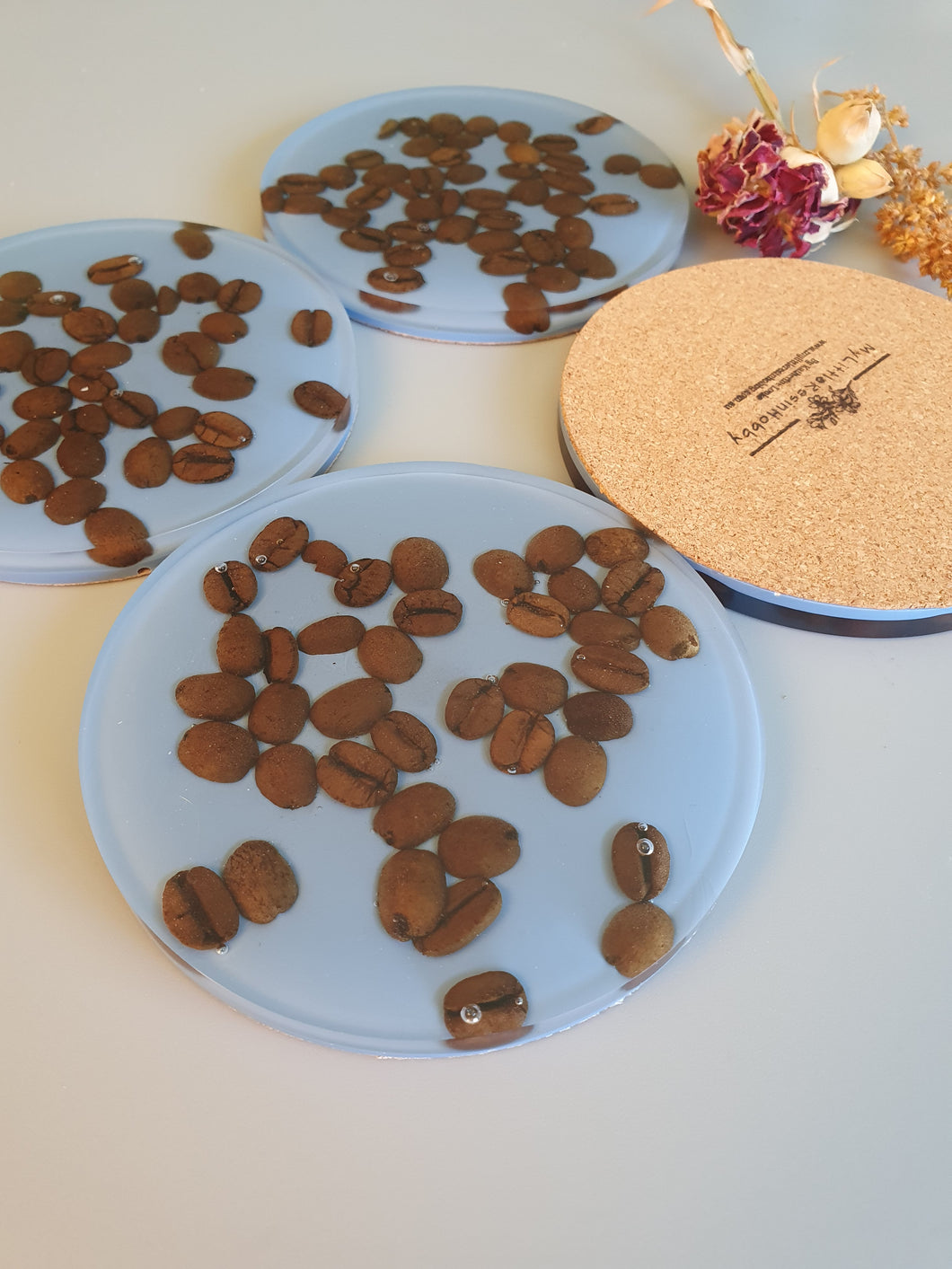 Fun coffee lover set of coasters with organic coffee beans encased in resin with a coloured background to brighten up your daily coffee while pairing as functional art. Created by Katherine Looke, Owner of Mylittleresinhobby.